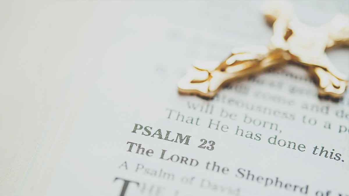 The Holy Bible open to Psalm 23 with a Crucifix atop the page