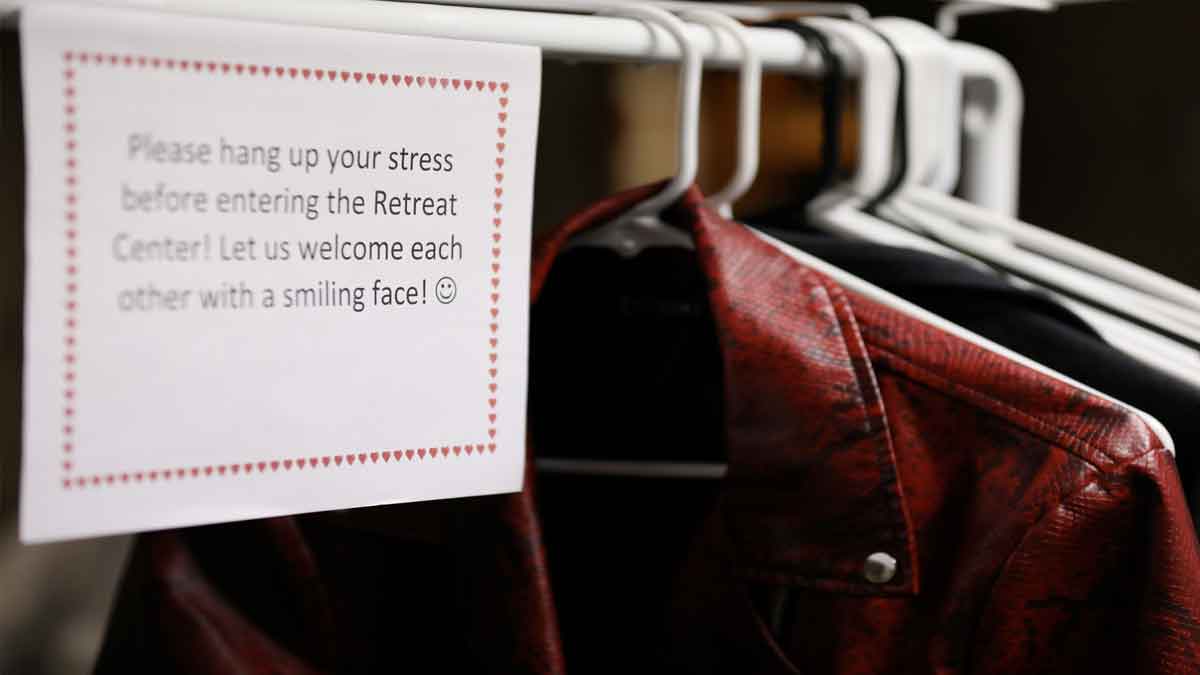 Coat hanger with sign: "Please hang up your stress before entering the Retreat Center. Let us welcome each other with a smiling face!