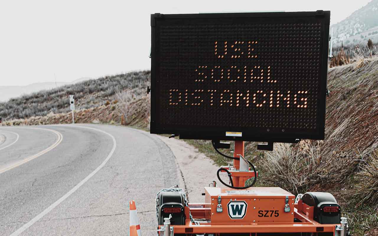 Electronic road construction sign that reads "Use Social Distancing"