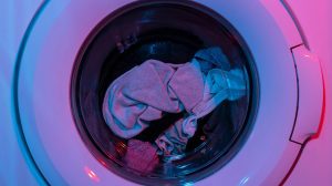 Close-up photograph of laundry machine washing clothes. By Engin Akyurt on unsplash.com.